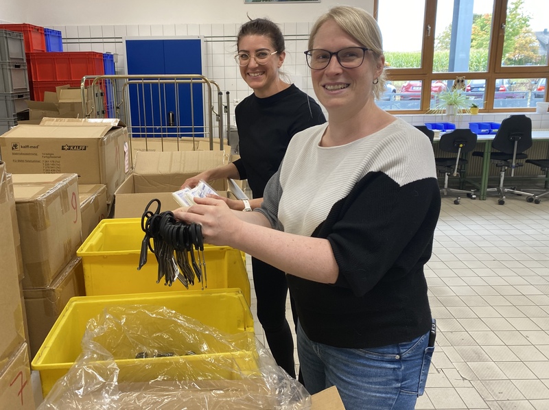 Kristina Cicek und Malena Hösl, Geschäftsführerin und Qualitätsmanagerin der Vital Products GmbH, holen Teile für die nächsten Verbandskästen aus den Verpackungen.