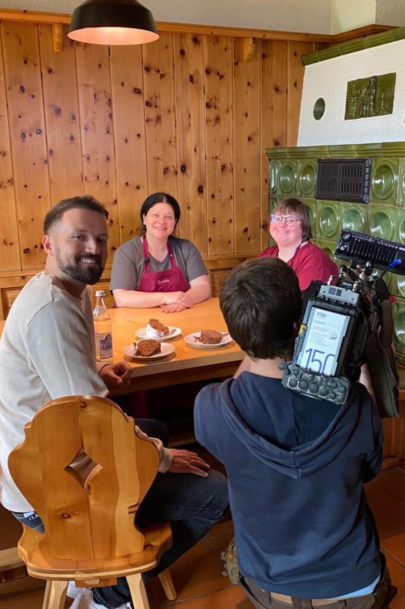 Mitarbeiter und Filmteam rund um einenTisch