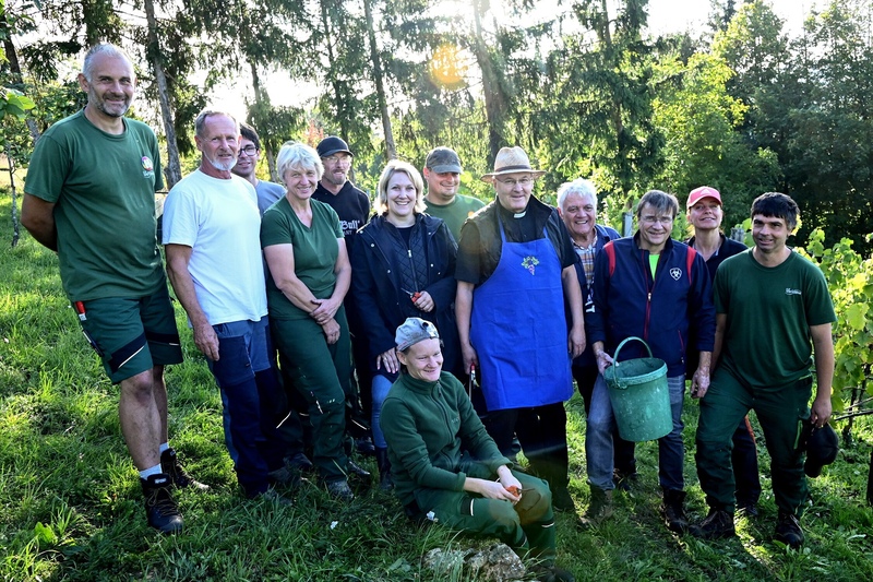 Gruppe der Erntehelfer im KJF-Weinberg mit Bischof Rudolf, KJF-Direktor Michael Eibl, Geschäftsführerin der KJF Werkstätten und des SIGMA Inklusionsbetriebs Melanie Eibl und stellvertr. Geschäftsführerin SIGMA Heidi Unger.