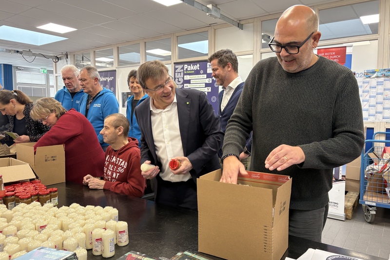 Hannes Ringlstetter bepackt gemeinsam mit KJF-Direktor Michael Eibl und weiteren Mitarbeitern aus den KJF Werkstätten Pakete für das Regensburger Weihnachtssingen.